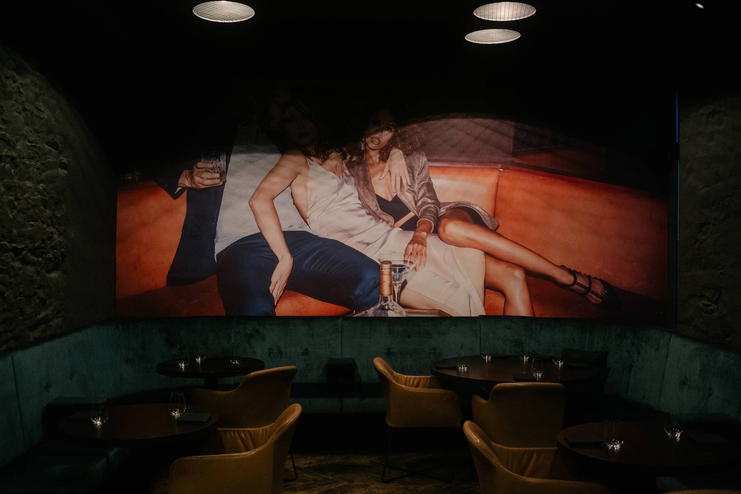 Einblick in eine elegante Restaurant-Lounge mit stilvollen Möbeln und einer großen Wandgrafik, ideal für gesellige Abende.