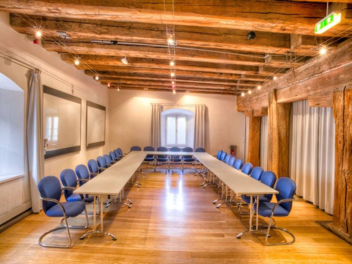 Tagungsraum im Hotel mit Holzdecke und blauen Stühlen, ideal für Meetings und Konferenzen in angenehmem Ambiente.