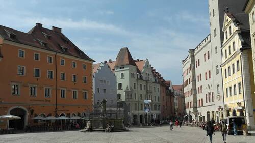 Der historische Marktplatz in Füssen zeigt bunte Häuser und eine belebte Cafégasse, ideal für einen Stadtbesuch.