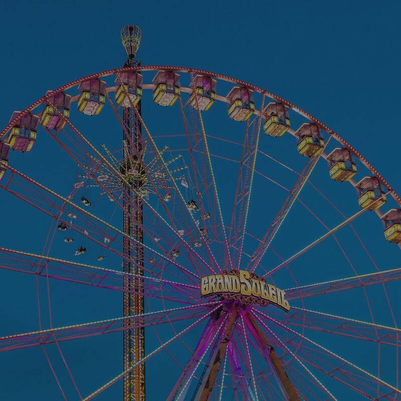 Das Riesenrad GRAND SOLEIL mit bunten Lichtern, ideal für Familienunterhaltung und Freizeitspaß bei Nacht.