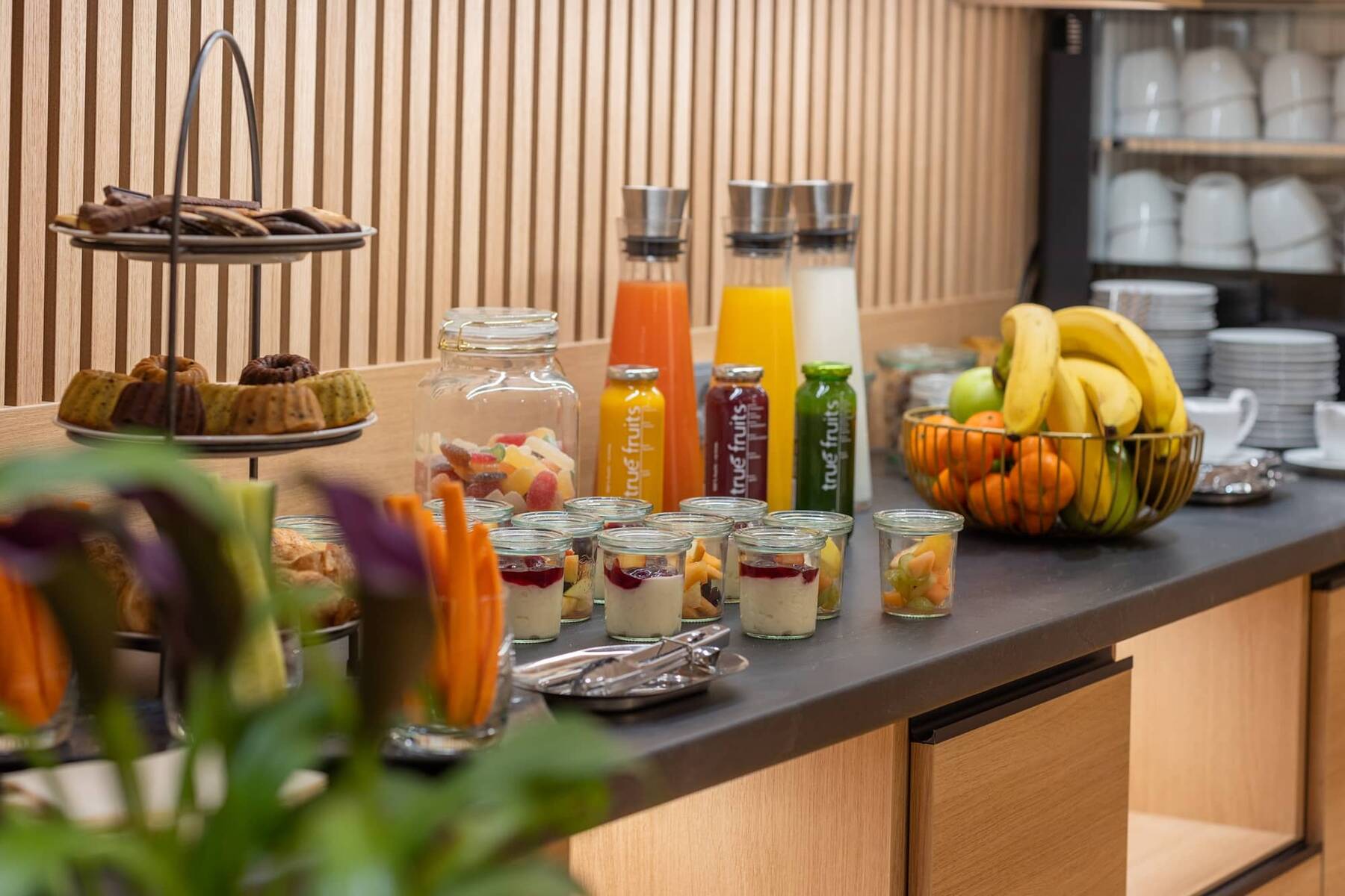 Frühstücksbuffet im Hotel mit frischen Früchten, Joghurt, Säften und Gebäck, ideal für einen Familienurlaub.