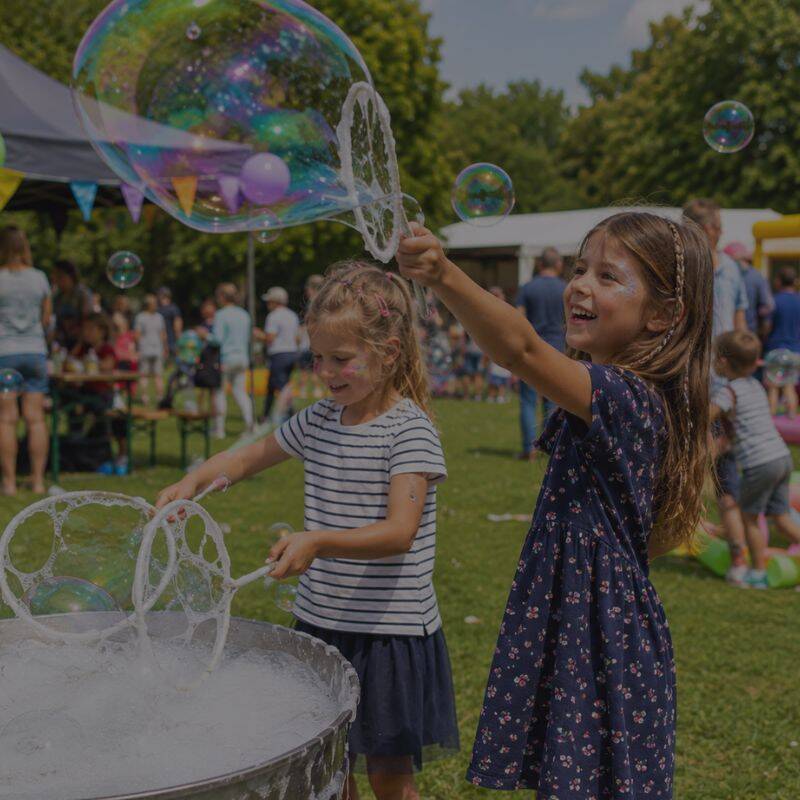 Zwei Kinder pusten riesige Seifenblasen auf dem Kinderbürgerfest Regensburg 2026 im Stadtpark