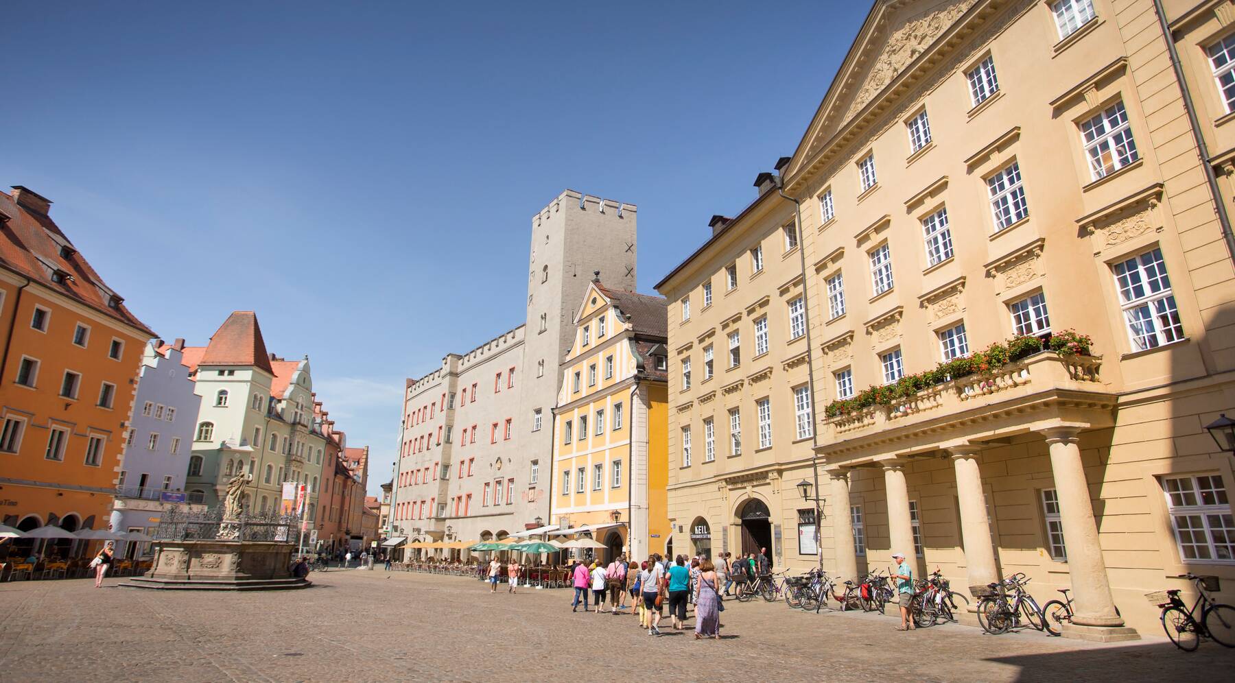 Blick auf die Altstadt mit bunten Häusern und einem Brunnen, ideal für einen Stadtbesuch in Bayern.