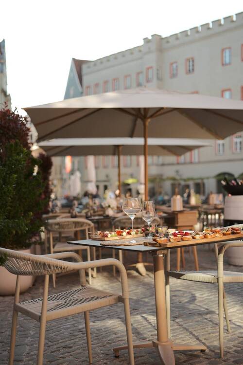 Outdoor terrace table at Maxim's Fine Wine Bar & Tapas at Haidplatz Regensburg with a generous tapas board and wine glasses in the evening light