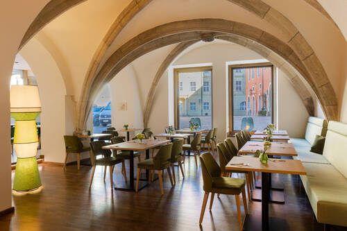 Das moderne Restaurant bietet gemütliche Sitzgelegenheiten mit Blick auf die Altstadt, ideal für einen entspannten Familienurlaub.